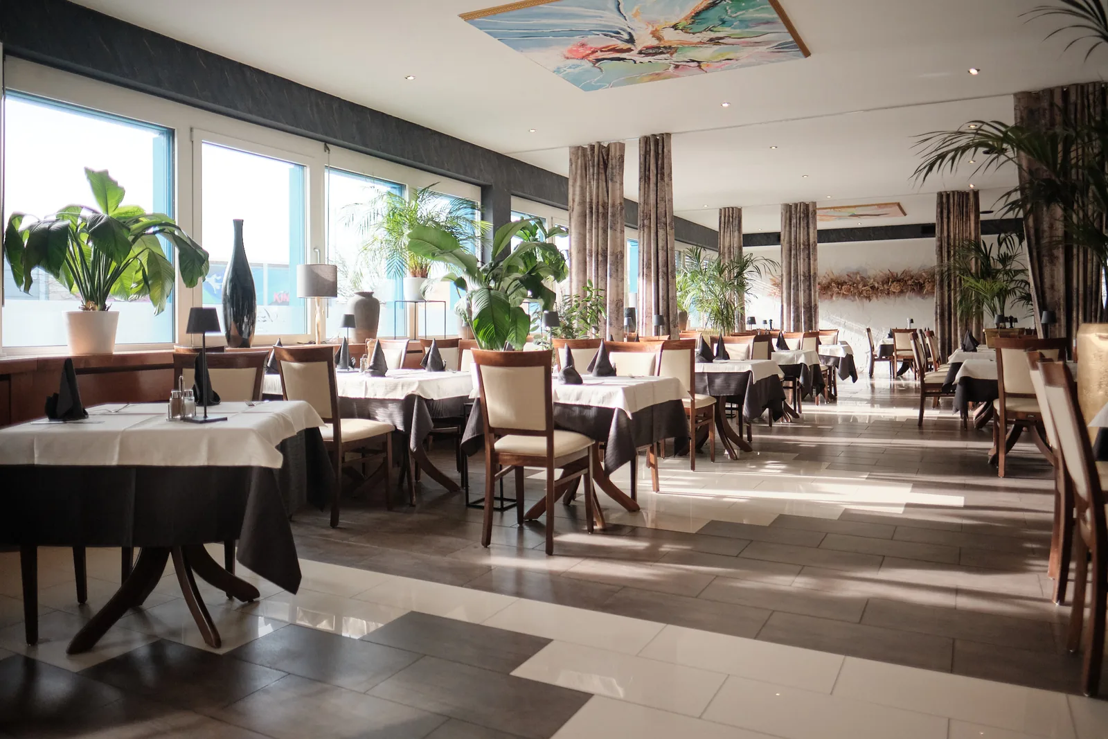 Speisesaal Ristorante Azzurro mit Pflanzen und gedeckten Tischen
