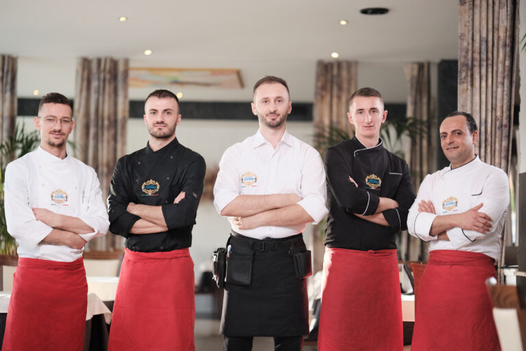 Teamfoto im Ristorante Azzurro in Königsbrunn: Links Servicekraft und ein Koch, in der Mitte der Inhaber, rechts ein Koch und ein Pizzabäcker.